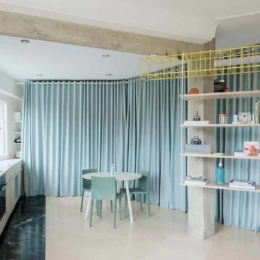 Azab replaces partitions with theatrical pale-blue curtains in a Bilbao apartment